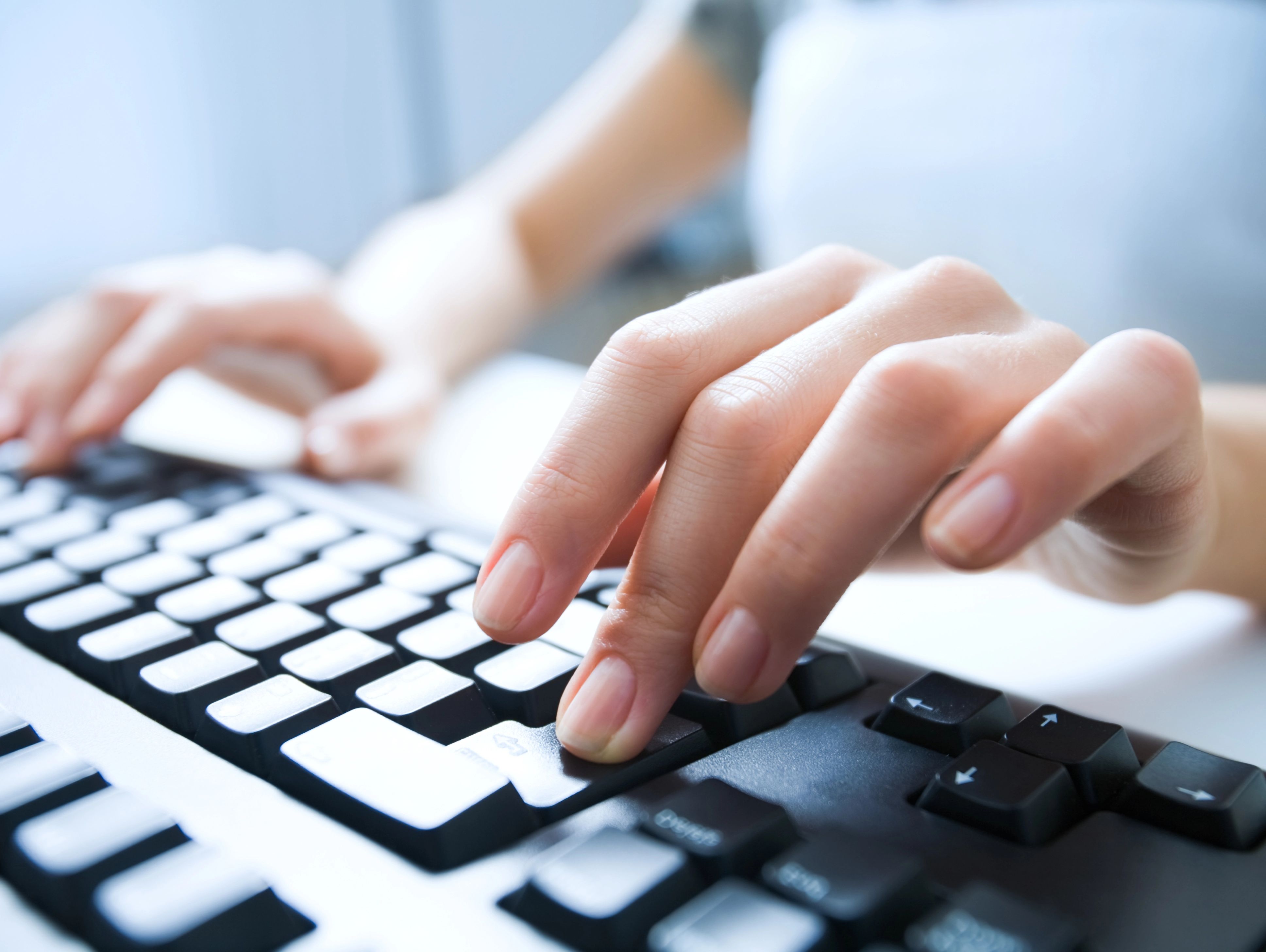 Das Bild zeigt zwei Hände auf einer Computer-Tastatur.